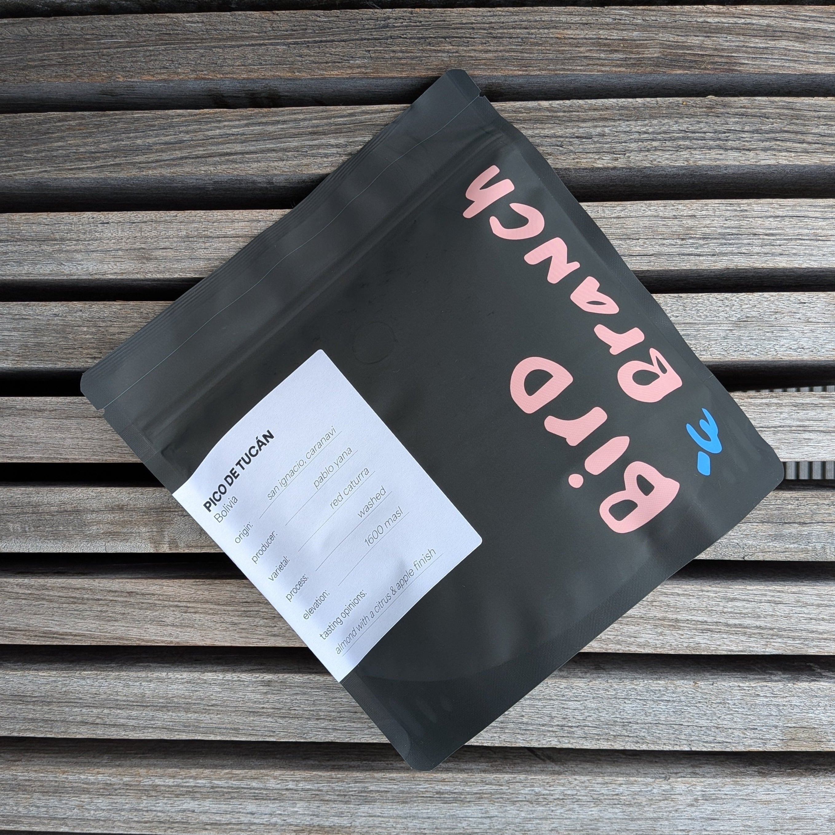 Black coffee bag with 'Bird & Branch' branding on a wooden surface - Bolivian whole bean coffee